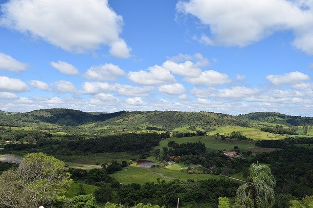 área verde com montanhas e arco iris