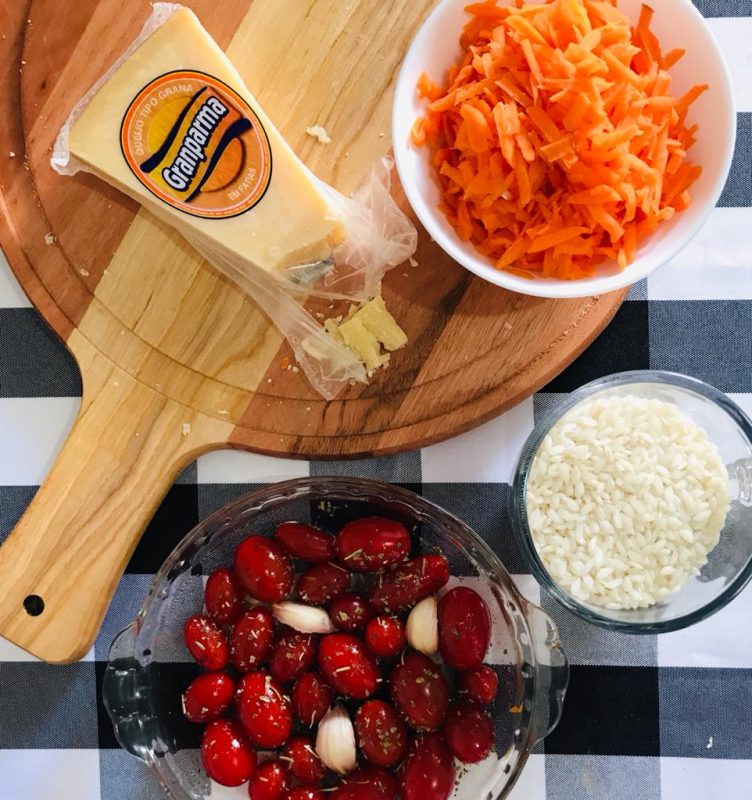 pratos de risoto com tomates assados em mesa de madeira