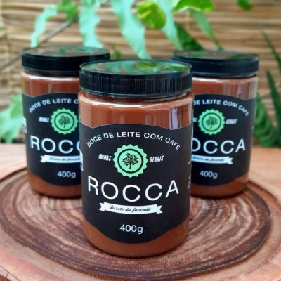Doce de leite com café Rocca sobre mesa de madeira, em embalagem de 400 gramas.
