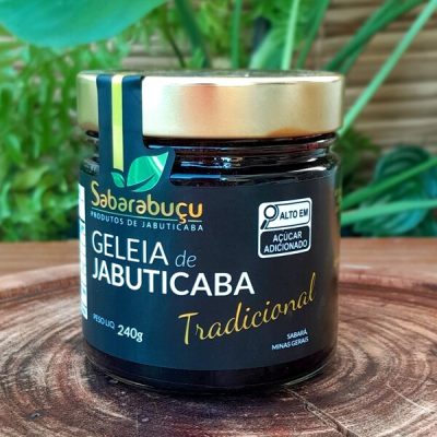 Geleia de jabuticaba Sabarabuçu em pote de vidro com 240 gramas, sobre mesa de madeira.