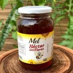 Mel em pote de vidro com 800 gramas, sobre mesa de madeira.