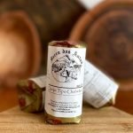 Queijo tipo Chabichou Serra das Antas embalado, sobre tábua de madeira.