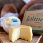 Queijo Canastra do Johne partido sobre tábua de madeira.