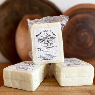 Queijo tipo feta Serra das Antas embalado à vácuo, sobre tábua de madeira.