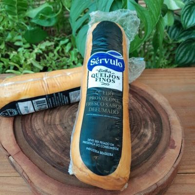 Queijo provolone defumado Sérvulo em embalagem fechada sobre mesa de madeira.