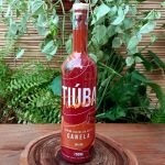 Tiuba canelinha em garrafa com 700 ml sobre mesa de madeira.