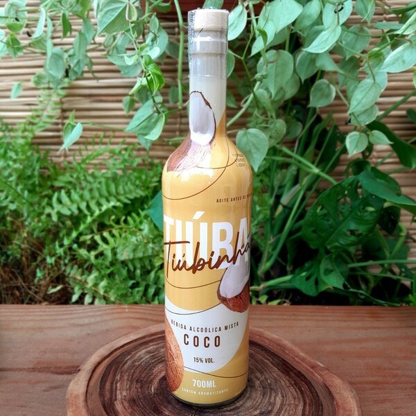 tiuba-coco Tiuba coco em garrafa com 700 ml sobre mesa de madeira.