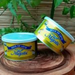 Doce de leite Majestic em lata de 460 gramas, sobre mesa de madeira.