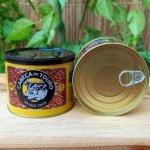 Manteiga cabeça de touro em lata fechada de 500 gramas sobre mesa de madeira.