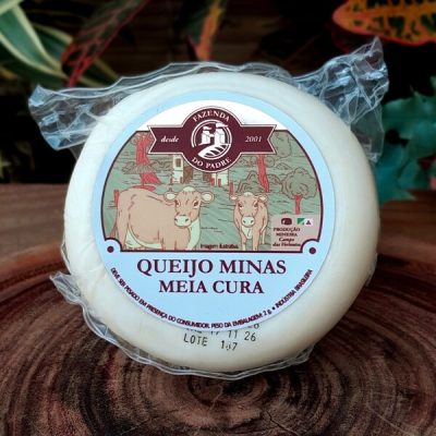 Queijo minas meia cura Fazenda do Padre sobre mesa de madeira.