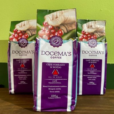 Café arábica em pacotes sobre mesa de madeira.