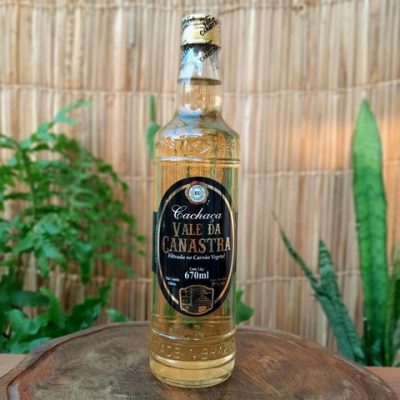 Cachaça Vale da Canastra em garrafa de 670ml sobre mesa de madeira.