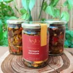 Caponata de beringela defumada sobre tábua de madeira.