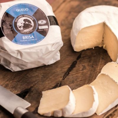 Queijo brisa partido sobre mesa de madeira.
