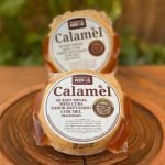 Queijo calambau meia cura defumado com mel, embalado sobre tábua de madeira.