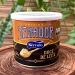 Doce de leite Senador em lata de 800 gramas sobre tábua de madeira.