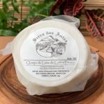 Queijo de cabra fresco Serra das Antas sobre mesa de madeira.