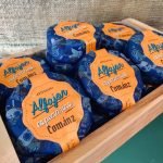 Alfajor de doce de leite cománz com especiarias, embalados e em caixa de madeira.