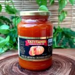 Doce de abóbora com coco em pote de vidro com 650 gramas, sobre mesa de madeira.