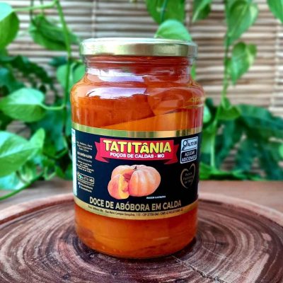 Doce de abóbora em calda em pote de vidro com 680 gramas, sobre mesa de madeira.
