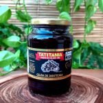 Geleia de jabuticaba com 680 gramas em pote de vidro sobre mesa de madeira.