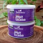 Doce de jabuticaba de corte Sabarabuçu, em lata de 400 gramas sobre mesa de madeira.