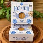 Doce de leite com coco Dona Lázara, em embalagem especial sobre mesa de madeira.