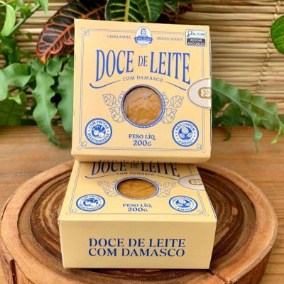 Doce de leite com damasco Dona Lázara, em embalagem especial sobre mesa de madeira.