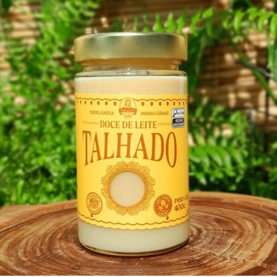 Doce de leite talhado Dona Lázara, em embalagem especial sobre mesa de madeira.