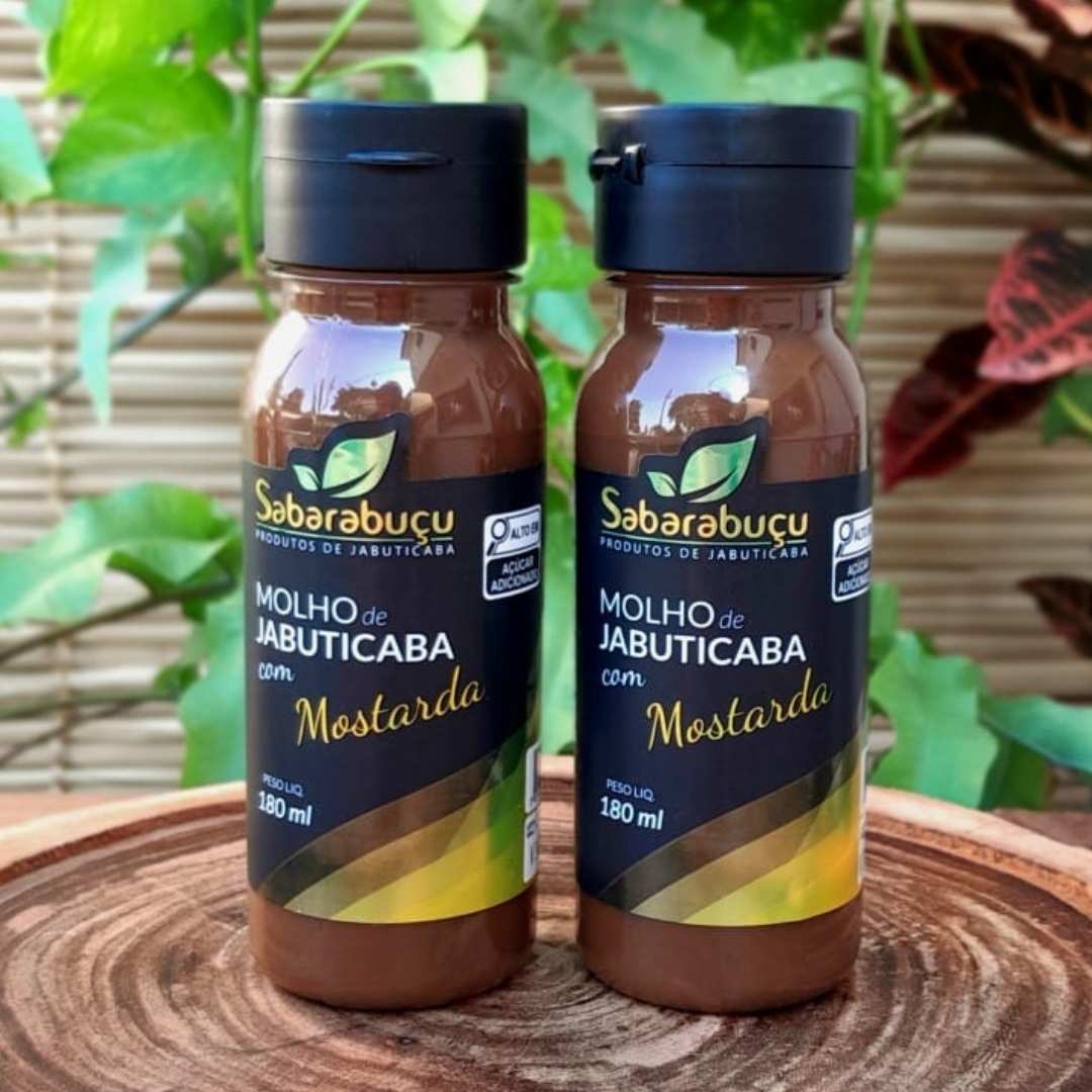 molho-de-jabuticaba-com-mostarda Molho de jabuticaba com mostarda Sabarabuçu, em frasco de plástico com 180 ml sobre mesa de madeira.