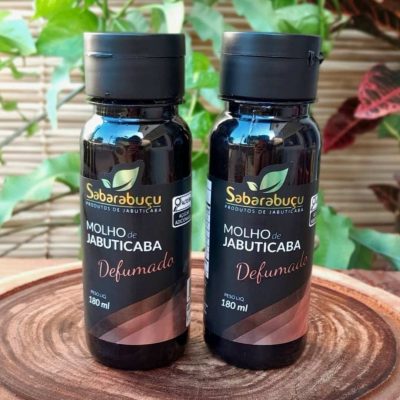 molho de jabuticaba defumado, em frasco de plástico com 180 ml sobre mesa de madeira.