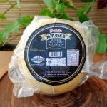 Queijo provolone recheado com requeijão Delícia Mineira, em peça inteira com aproximadamente 500 gramas sobre mesa de madeira.
