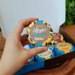 Alfajor Cománz em kit com 6 sabores, em caixa especial sobre mesa de madeira.