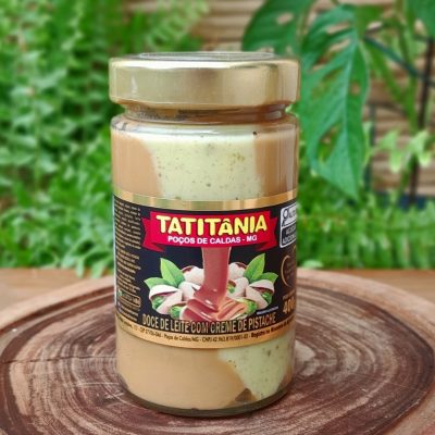 Doce de leite com pistache Tatitânia em embalagem de 400 gramas, sobre mesa de madeira.