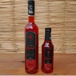 Licor de morango Prosa Mineira produzido com cachaça, em garrafa de 500 ml sobre mesa de madeira.