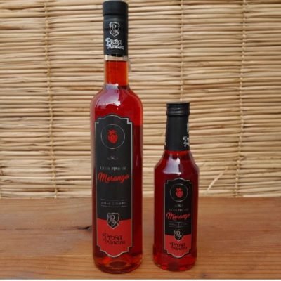 Licor de morango Prosa Mineira produzido com cachaça, em garrafa de 500 ml sobre mesa de madeira.