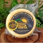 Queijo artesanal de Alagoa Fazenda Bela Vista sobre mesa de madeira.