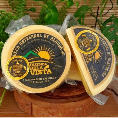 Queijo artesanal de Alagoa Fazenda Bela Vista sobre mesa de madeira.