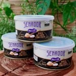 Doce de leite com coco Senador em lata com 400 gramas, sobre mesa de madeira.