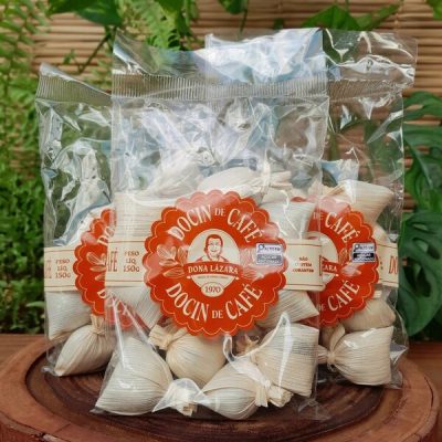 bala de café na palha dona lázara, em embalagem com 150 gramas sobre mesa de madeira.