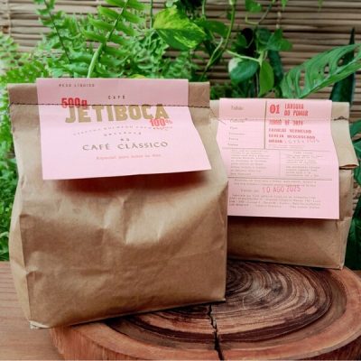 Café Jetiboca em grãos com torra média em embalagem de 500 gramas sobre mesa de madeira.