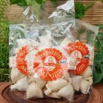 Doce de leite na palha Dona Lázara em embalagem com 150 gramas, sobre mesa de madeira.