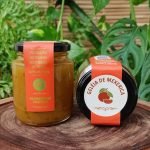 Geleia de mexerica em pote com 280 gramas, sobre mesa de madeira.