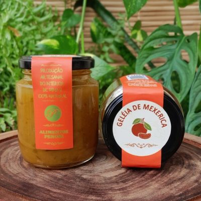 Geleia de mexerica em pote com 280 gramas, sobre mesa de madeira.