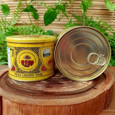 Manteiga Real em lata de 500 gramas, sobre mesa de madeira.