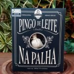 Pingo de leite na palha Dona Lázara em caixa com 100 gramas, sobre mesa de madeira.