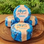 Alfajor flor de sal Cománz embalado, sobre mesa de madeira.