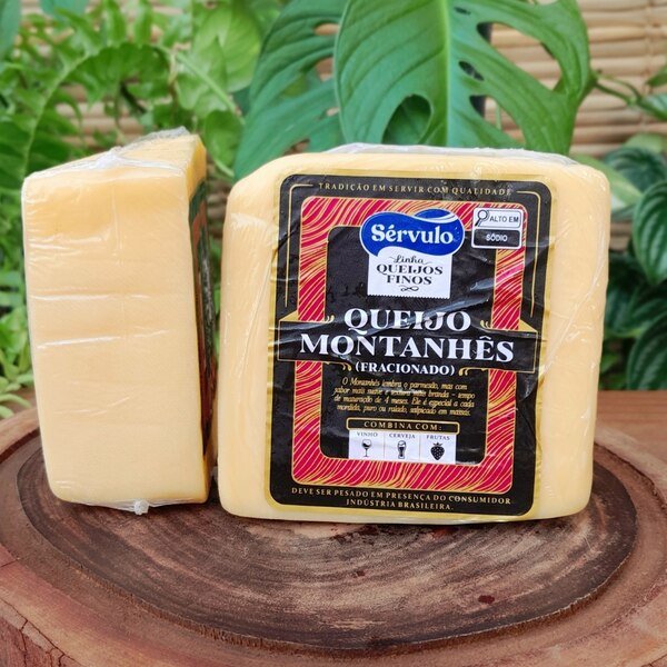 queijo-montanhes-servulo Queijo Montanhês Sérvulo em fração de aproximadamente 350 gramas embalada à vácuo, sobre mesa de madeira.