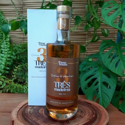 Cachaça Três Madeiras Prosa Mineira em garrafa com 800 ml sobre mesa de madeira.