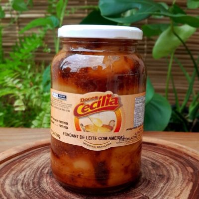 Doce de leite com ameixas da Doces Cecília, em pote de vidro com 700 gramas, sobre mesa de madeira.